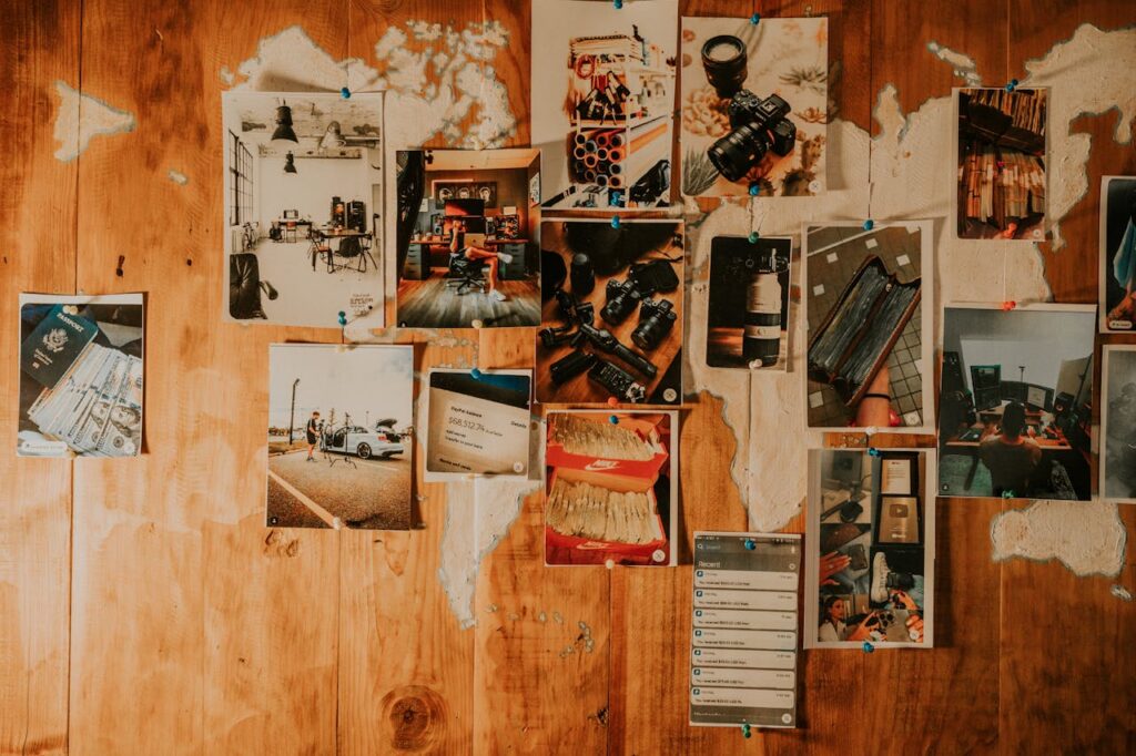 Artistic arrangement of various photographs pinned on a wooden wall, showcasing creativity.